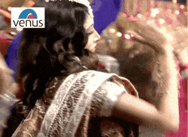 a woman is dancing with a venus logo in the background