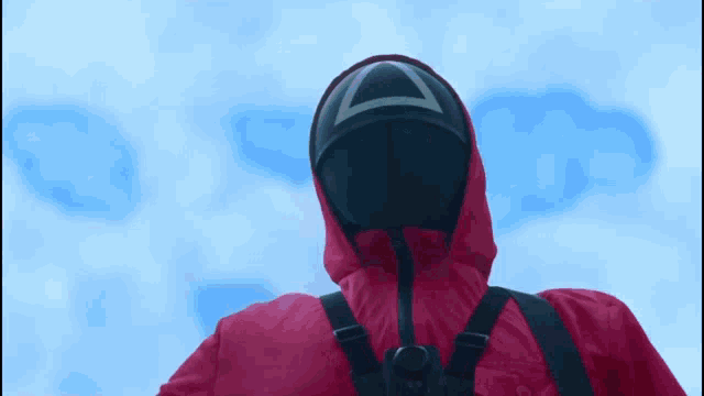 a person in a red jacket with a mask on their face