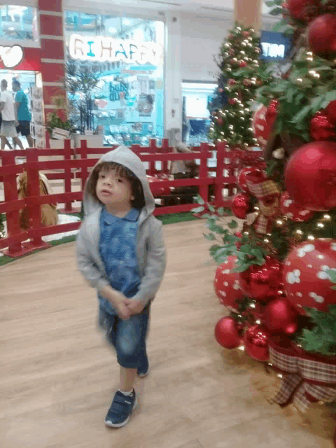 a little boy is standing in front of a store that says rihappy