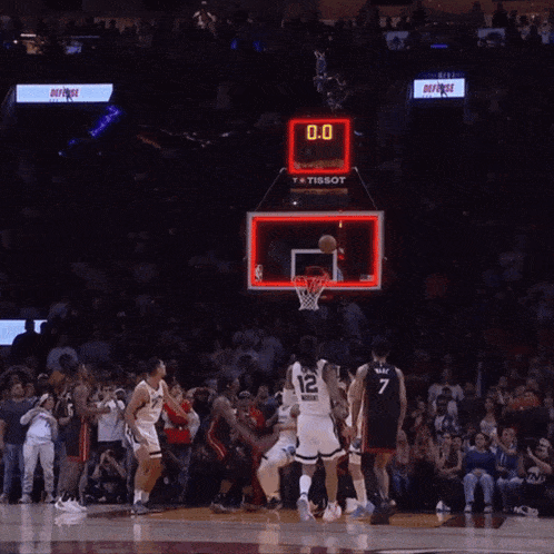 a basketball player with the number 12 on his jersey jumps in the air