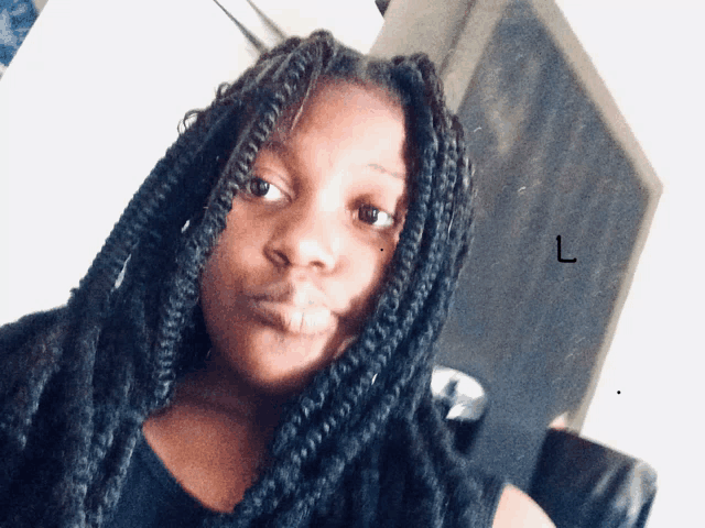 a woman with braided hair has the letter l on her face