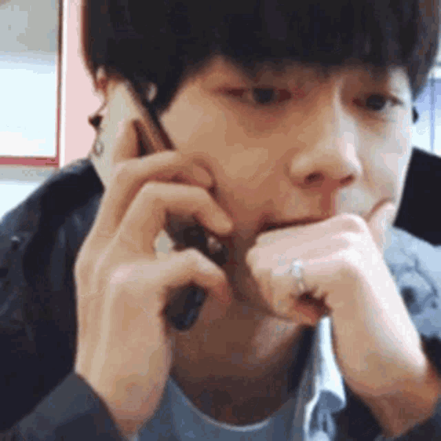 a man with a ring on his finger is talking on a cellphone