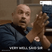 a man is clapping his hands in a very well said sir gif .