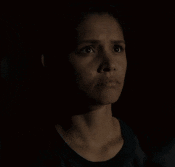 a close up of a woman making a funny face in the dark .