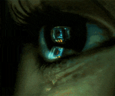 a close up of a woman 's eye with a reflection of a person 's face in it
