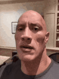 a close up of a bald man making a funny face in a room .