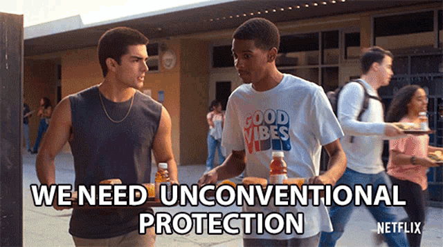 a man wearing a good vibes t-shirt walks with another man