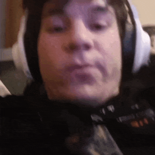 a close up of a man wearing headphones and making a face .