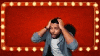 a man is holding his head in front of a red background with lights on it .