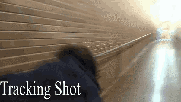a person walking down a hallway with the words tracking shot below them