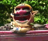 a cartoon character with a yellow hat and pink nose is laughing .