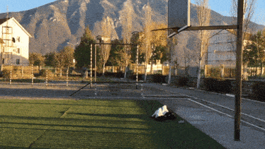 a basketball court with mountains in the background and a basketball hoop