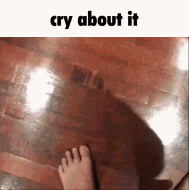 a person 's foot is standing on a wooden floor with the words cry about it below it