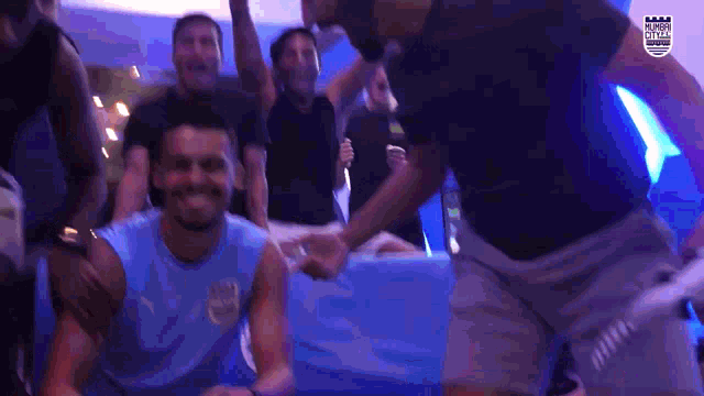 a man in a blue shirt with the word argentina on it is surrounded by other people