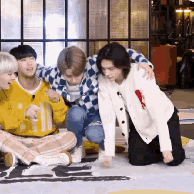 a group of young men are sitting on the floor and playing a game .