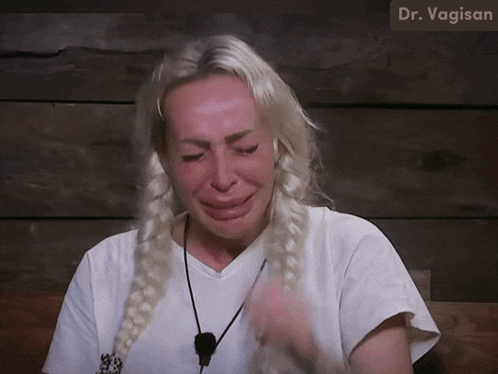 a woman is crying in front of a sign that says dr vagisan
