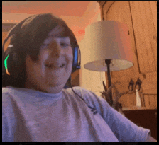 a man wearing headphones is smiling in front of a lamp in a living room