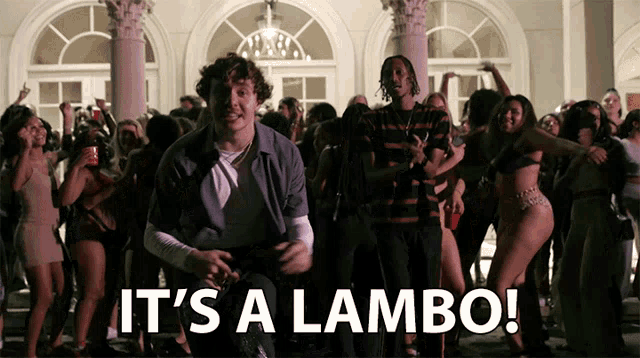 a man dancing in front of a crowd with the words it 's a lambo below him