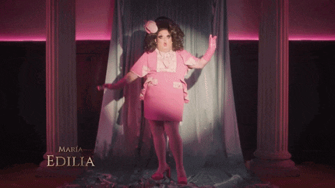 a drag queen in a pink dress with the name maria edilia