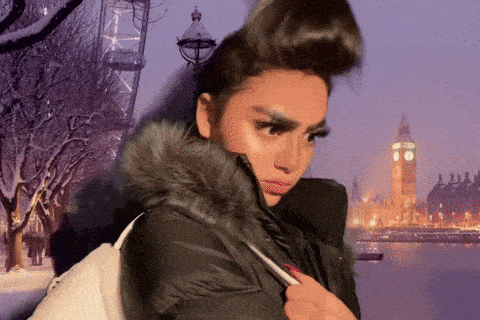 a woman wearing a fur hooded jacket stands in front of the big ben clock tower