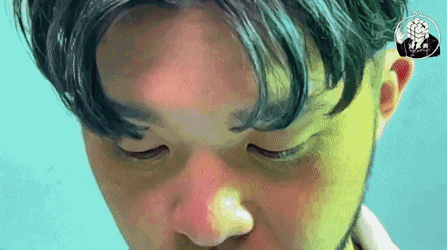 a close up of a man 's face with his eyes closed and a sticker that says ' a ' on it