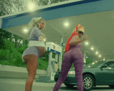 two women are standing in front of a gas pump that says pepsi on it