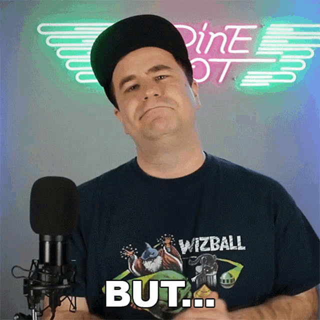 a man wearing a shirt that says wizball but stands in front of a microphone