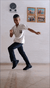 a boy in a white shirt is jumping in the air in front of a wall with pictures on it that say ' swimming '
