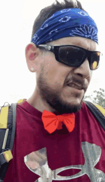 a man wearing sunglasses and a bandana has an under armour shirt