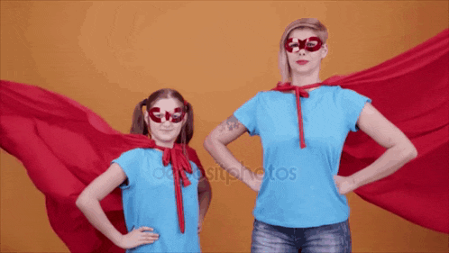 a woman and a little girl are dressed in superhero costumes with their hands on their hips
