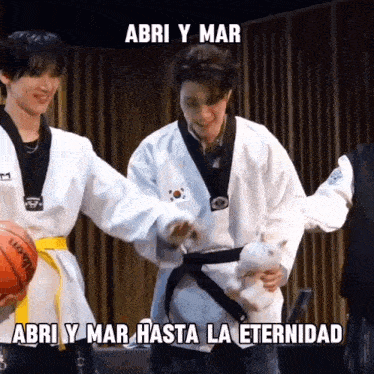 a man in a karate uniform is holding a stuffed animal while another man holds a wilson basketball ..