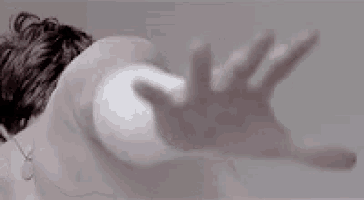 a close up of a person 's hand reaching out towards another person .