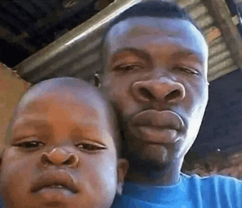 a man and a child are posing for a picture together . the child has a big nose .