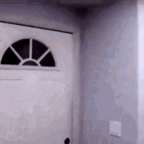 a white door with a stained glass window is in a room .