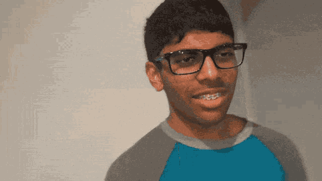 a young man wearing glasses and a blue shirt