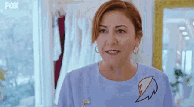 a woman is wearing a blue shirt with a signature on it .