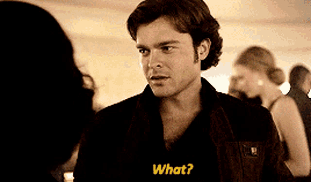 a man is talking to a woman and says " what " in yellow