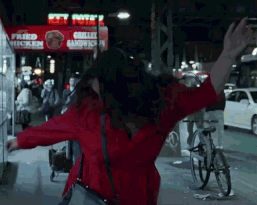 a woman is dancing in front of a sign that says grilled chicken