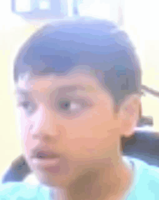 a close up of a young boy 's face with his mouth open .