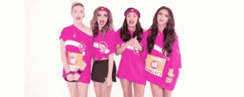 a group of girls are standing next to each other wearing pink shirts and headbands .
