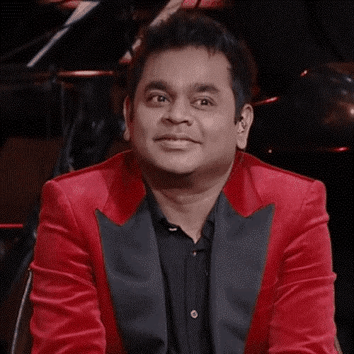 a man wearing a red jacket and a black shirt is smiling and looking at the camera .