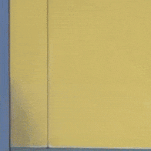 a cartoon cat sticking its tongue out while peeking out from behind a wall