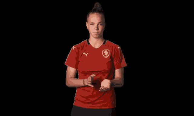 a woman in a red shirt with a shield on it