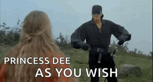 a man in a mask is standing next to a woman in a field with the words `` princess dee as you wish '' .