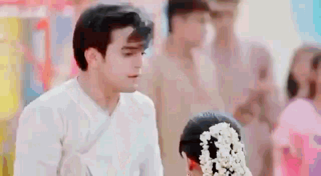 a man and a woman are standing next to each other in front of a crowd of people .