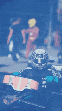 a man wearing a petronas helmet sits in a race car