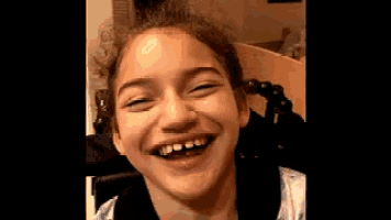 a young girl with a missing tooth is smiling .