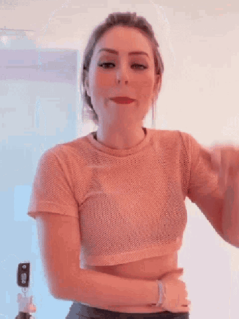 a woman is pointing her finger at the camera while wearing red lipstick .