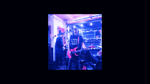 a man playing a guitar with a shirt that says " i want peace i gave " on it