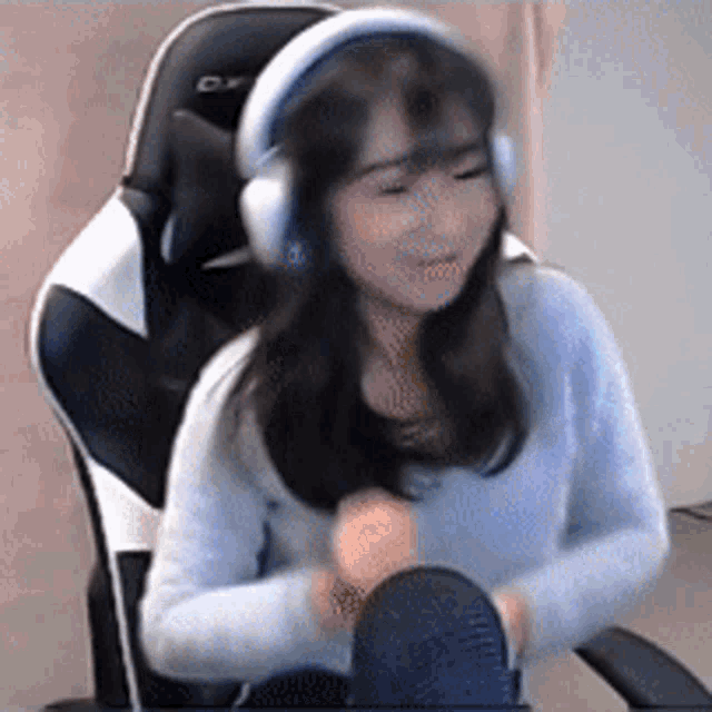 a woman is sitting in a chair wearing headphones and a microphone .